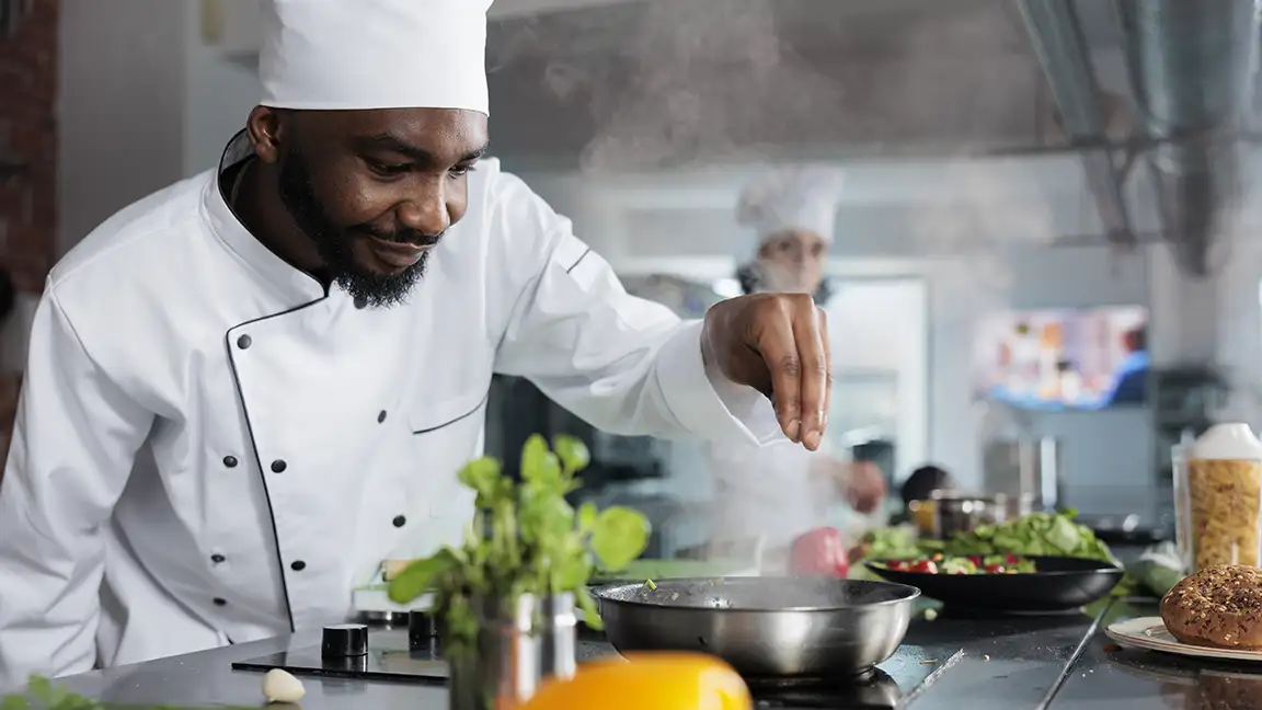 Restaurant chef preparing a dish with local seasonal ingredients